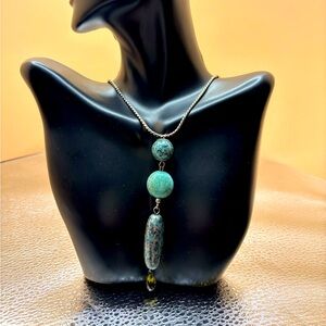 A 35” turquoise tone statement necklace with matching earrings